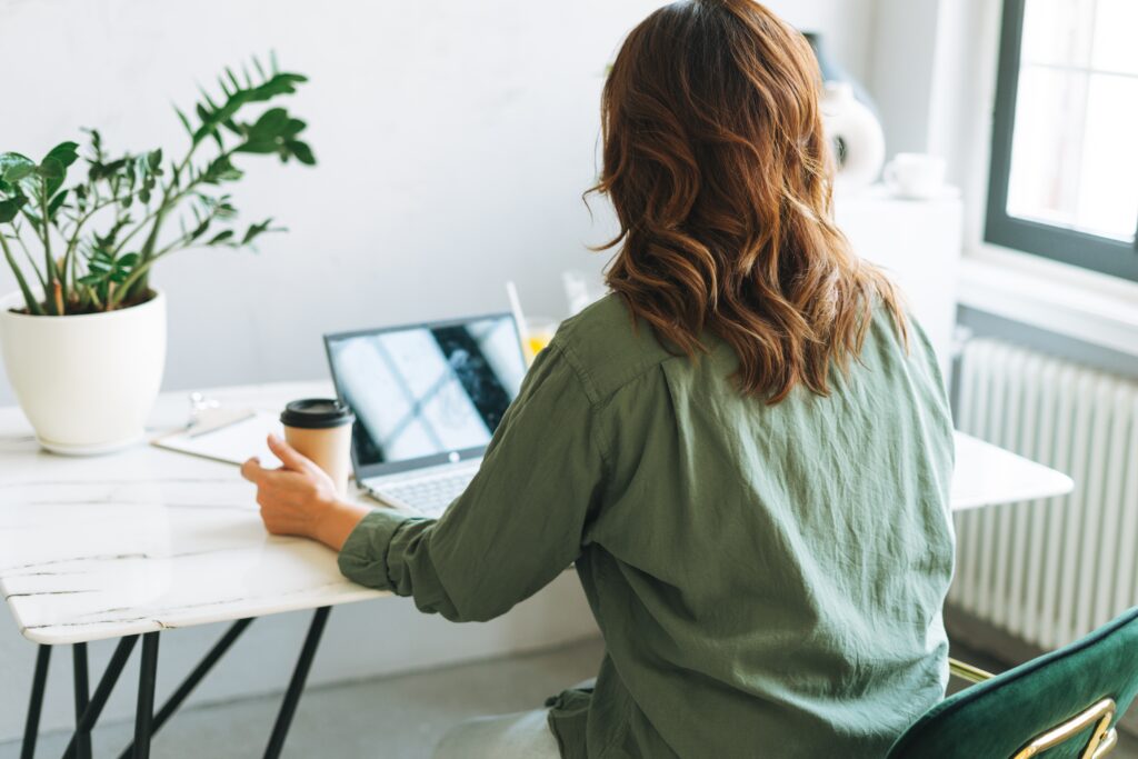 Coach Be Jen devant son ordinateur qui enseigne lors du programme en groupe en contact avec ses clients