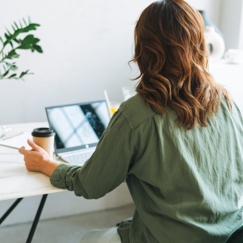 Coach Be Jen devant son ordinateur qui enseigne lors du programme en groupe en contact avec ses clients